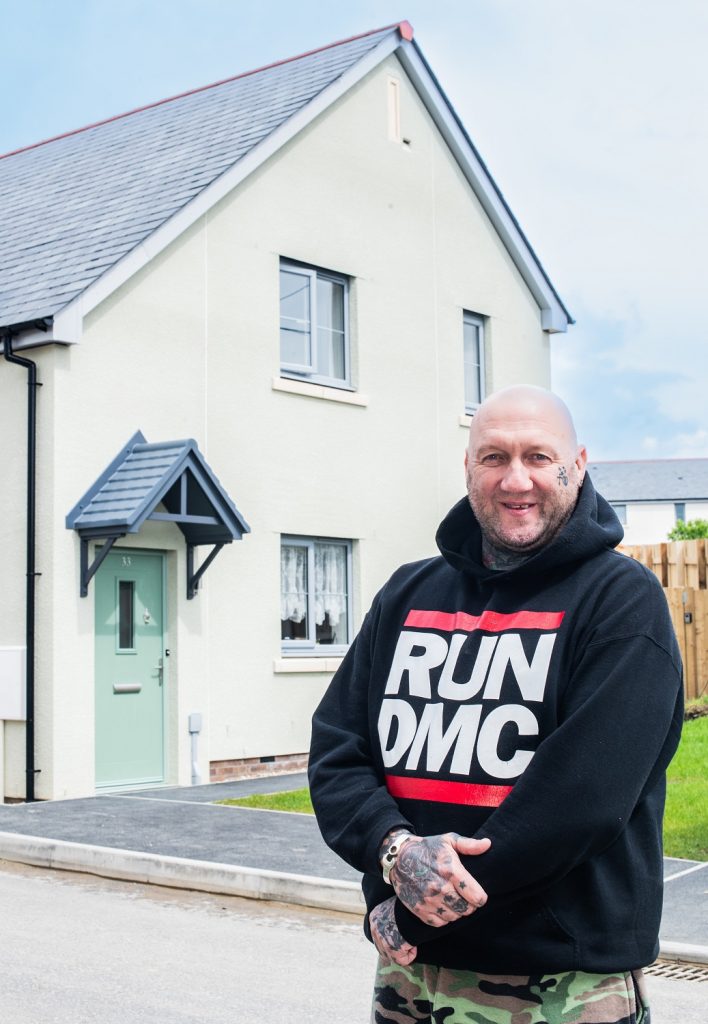 Man standing in front of a new house